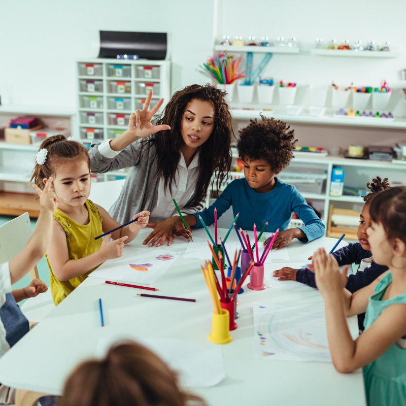 an art teacher helping her young students learn to draw
