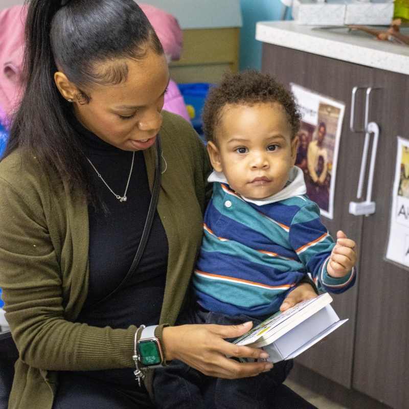 Mother reading to her son who sits in her lap