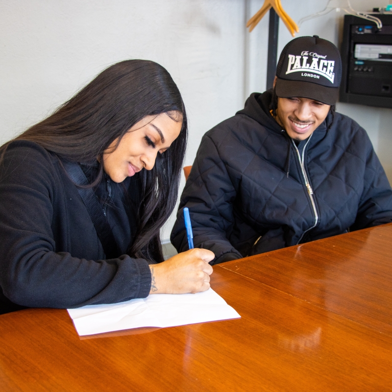 A woman signing a paper on a desk